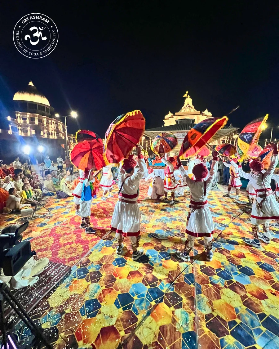 Rajasthani dancers in front of illuminated Om Ashram for Holi.